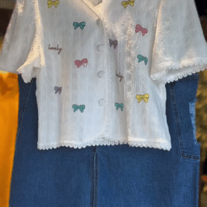 Charming White Textured Short Sleeve Button-Up Top with Multicolor Bow Embroidery and Lovely Text Print Paired with Stylish Blue Denim Midi Skirt...