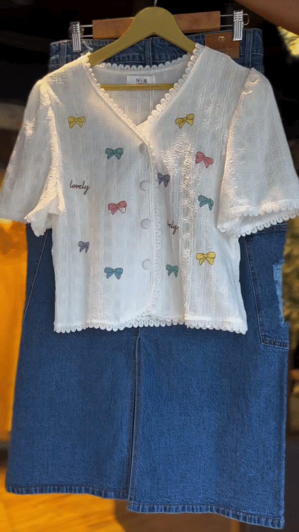 Charming White Textured Short Sleeve Button-Up Top with Multicolor Bow Embroidery and Lovely Text Print Paired with Stylish Blue Denim Midi Skirt...